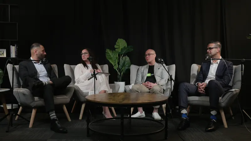 A four-person Ryker Capital panel in grey armchairs round a timber table on the Lounge set, a plant between them