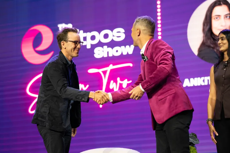 Two presenters shaking hands on stage