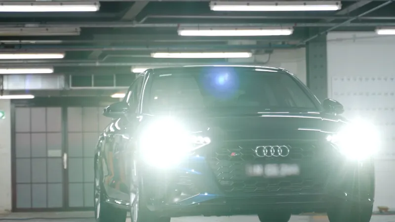 Car headlights on in a dark car park