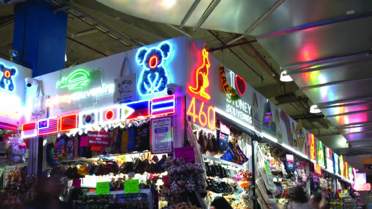 The 460 Sydney Souvenirs storefront, lit with neon signs.