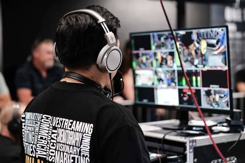 Livestream operator switching cameras at a powerlifting event