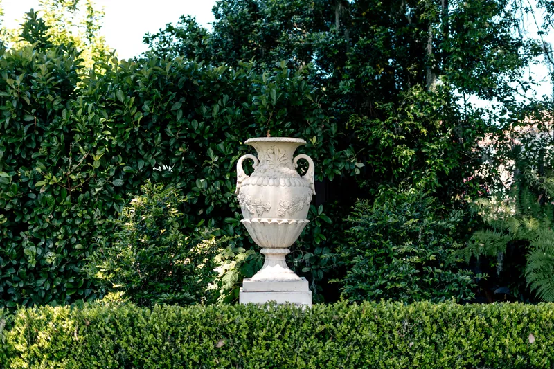 Stone urn in a hedged garden